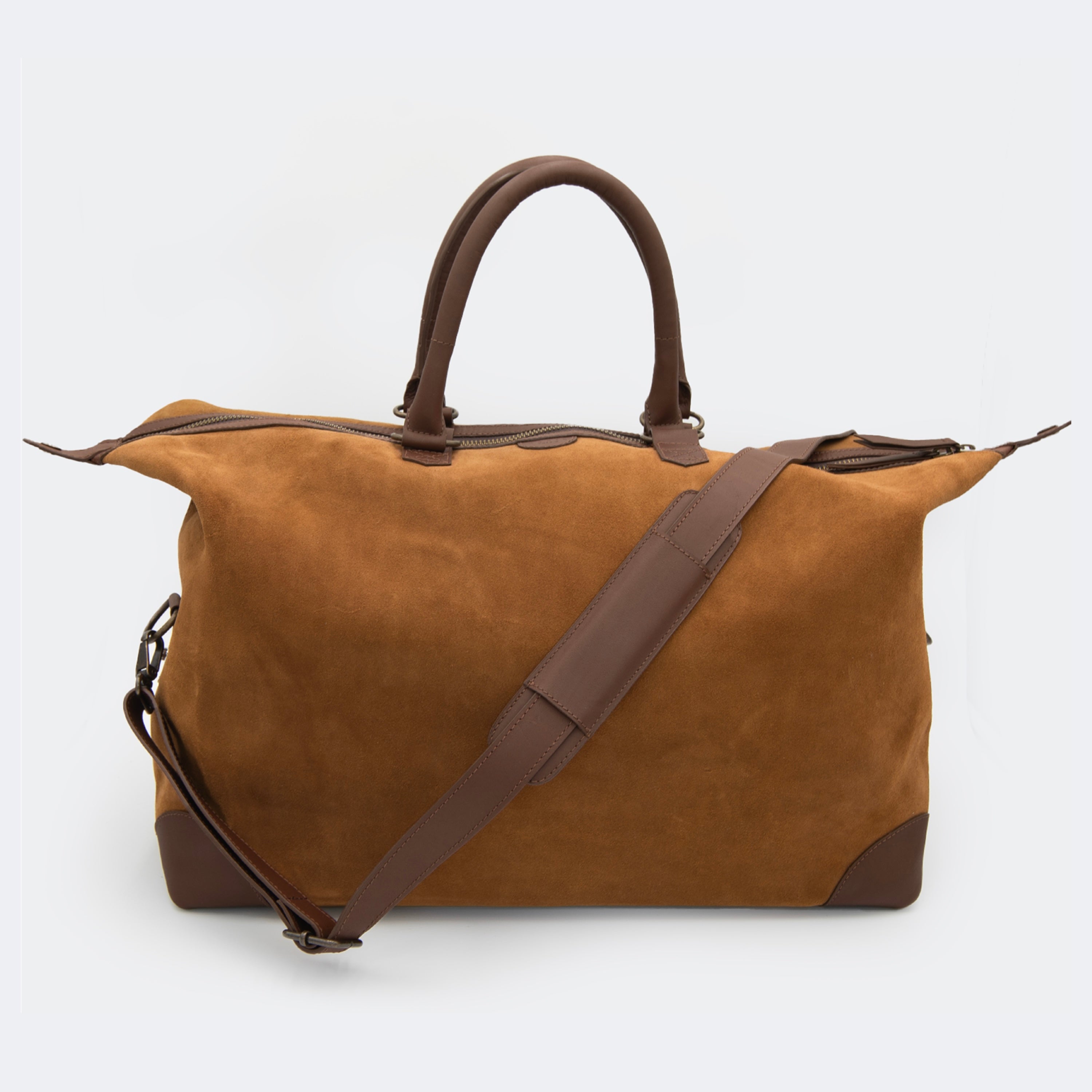 The Valise in brown leather, shown with its removable full-grain leather shoulder strap attached — designed for hands-free carry and versatile travel.