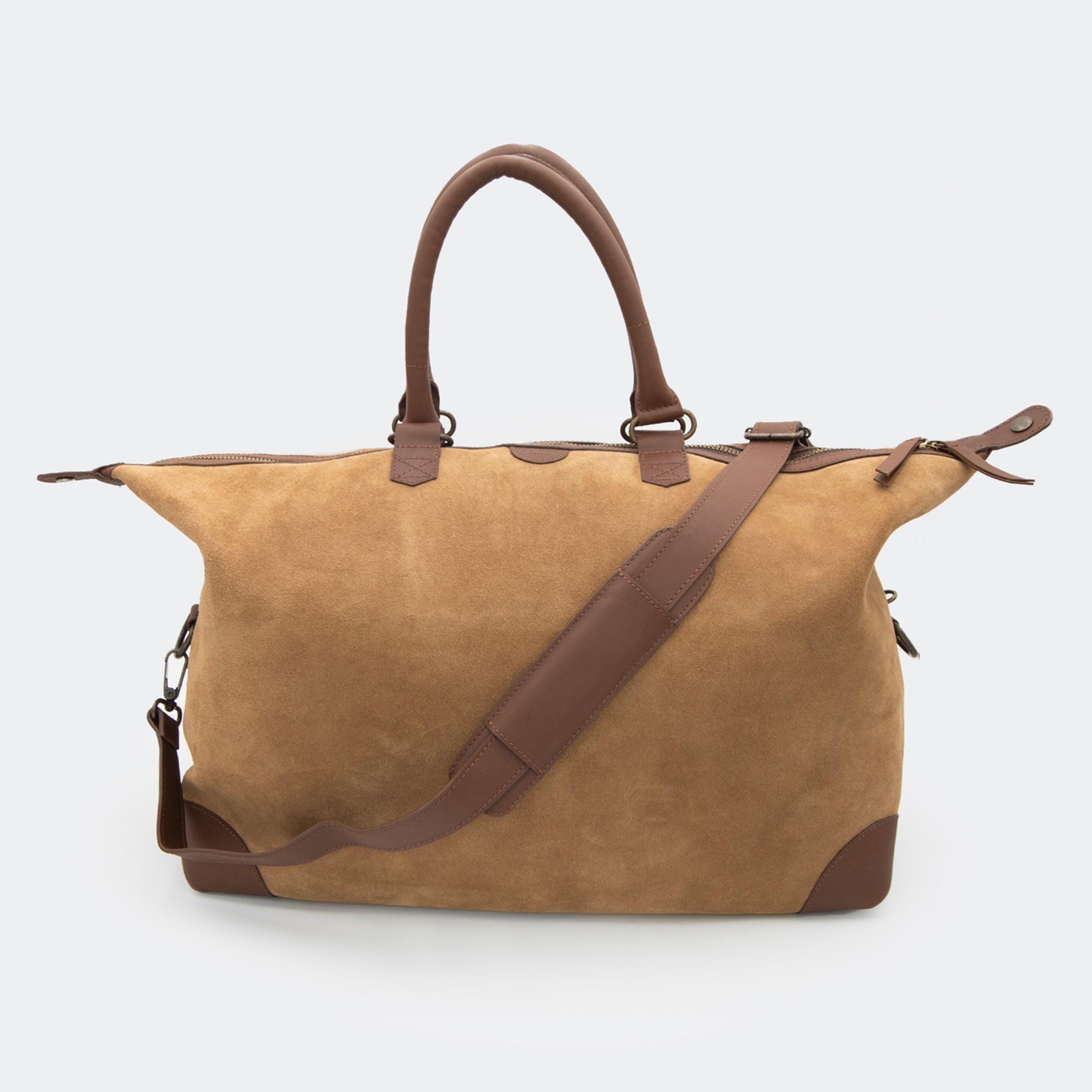 The Valise in brown leather, shown with its removable full-grain leather shoulder strap attached — designed for hands-free carry and versatile travel.