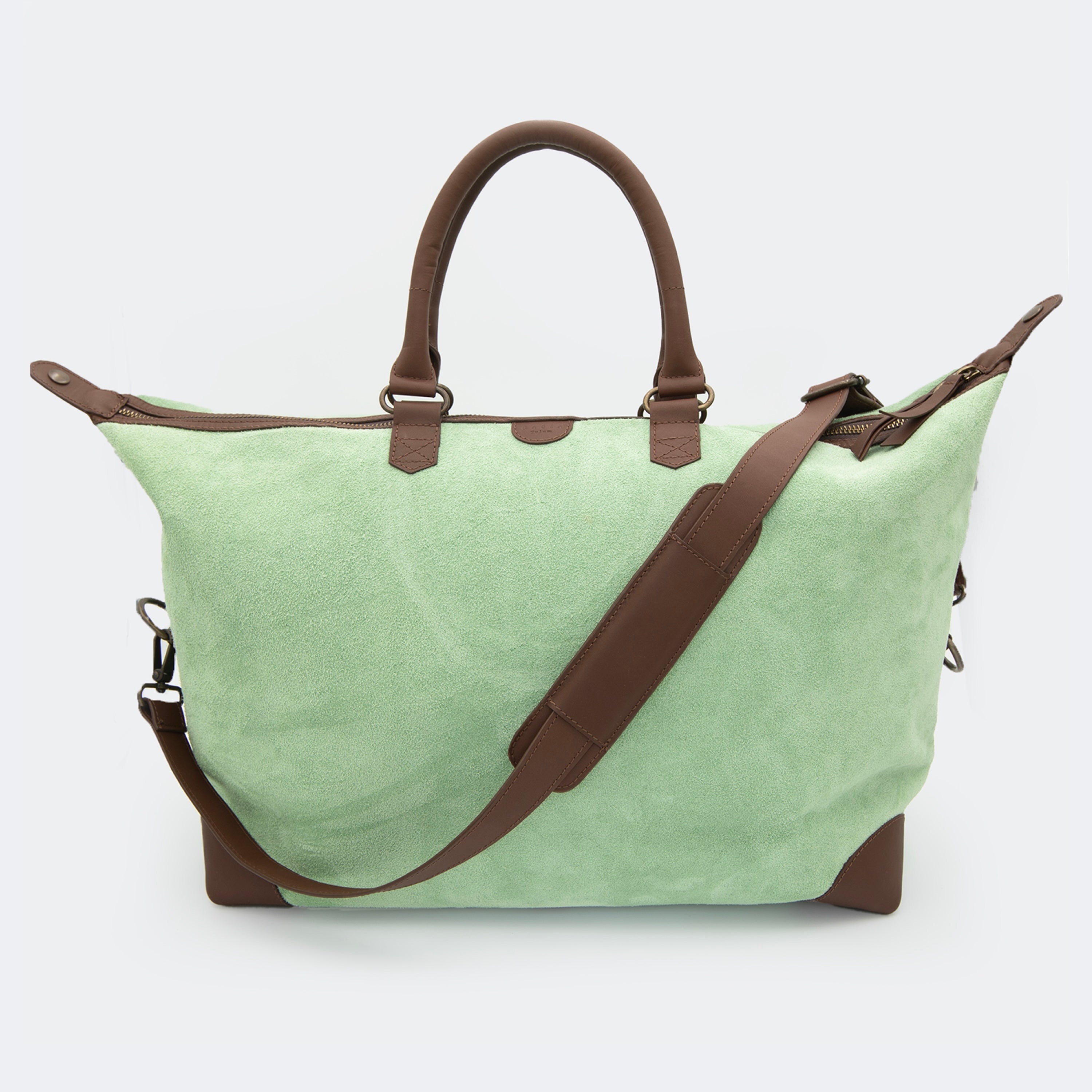 The Valise in mint green leather, shown with its removable full-grain leather shoulder strap attached — designed for hands-free carry and versatile travel.