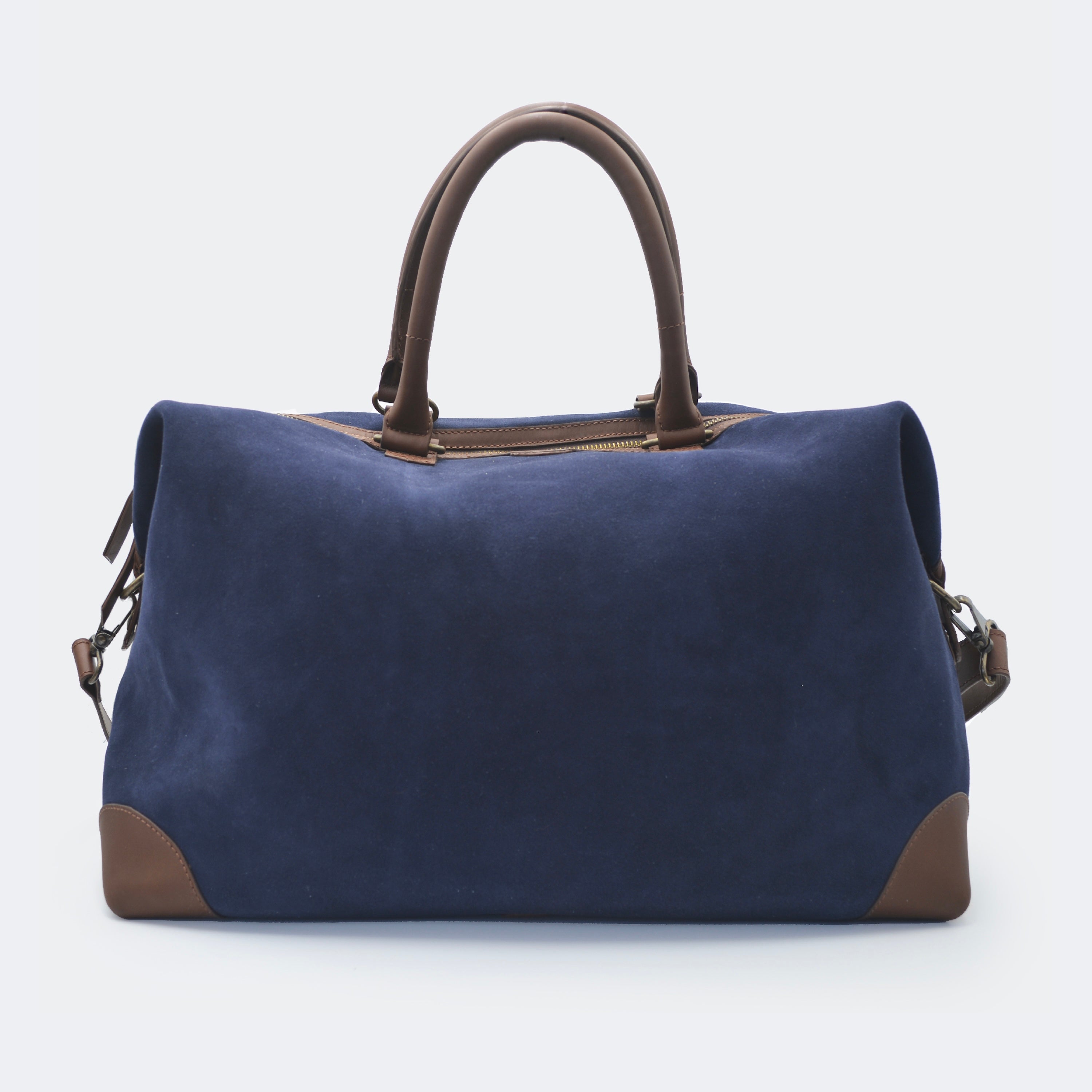 The Valise in navy blue leather, crafted from full-grain leather with structured sides and curved handles — a minimalist travel bag blending elegance and utility.