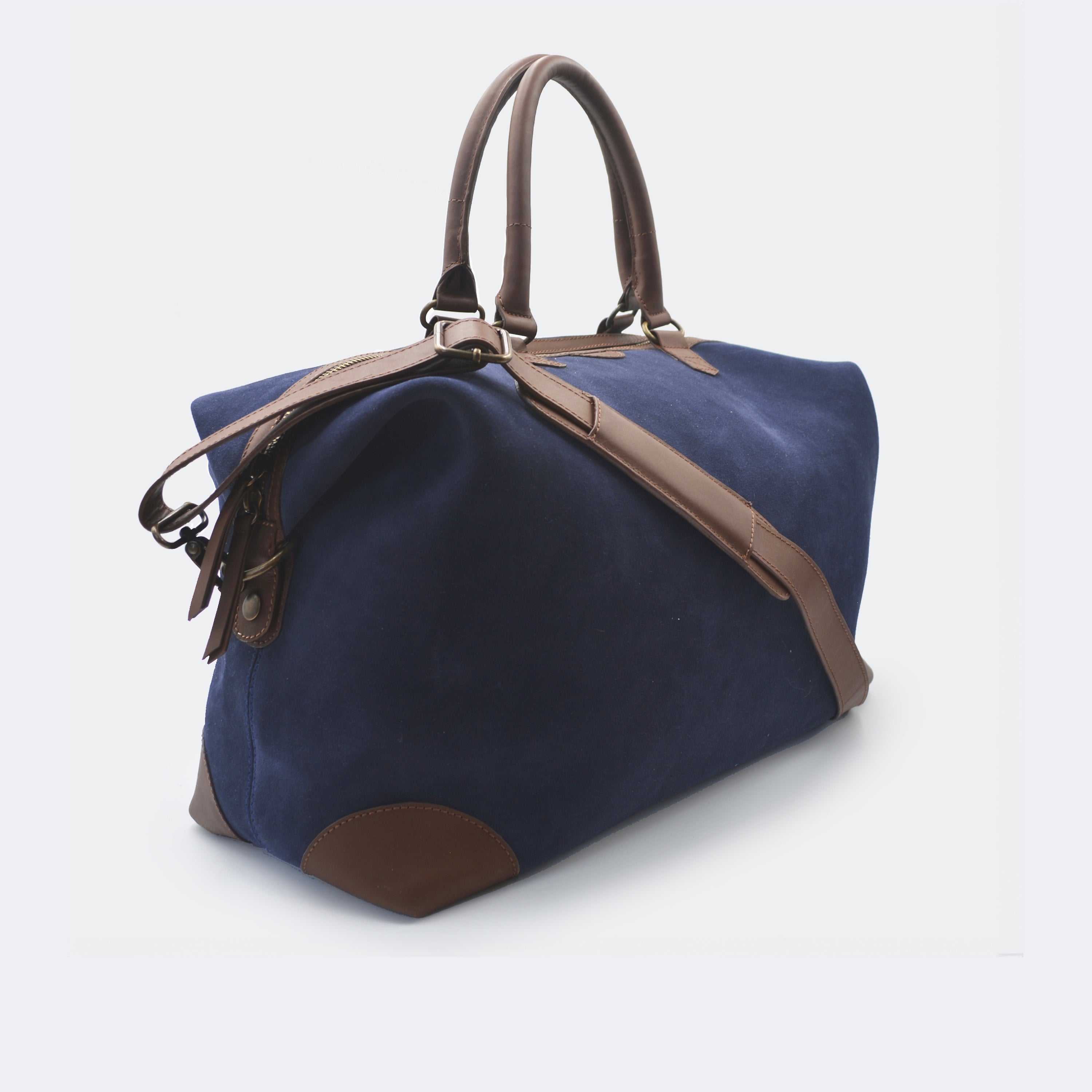The Valise in navy blue leather, shown with its removable full-grain leather shoulder strap attached — designed for hands-free carry and versatile travel.