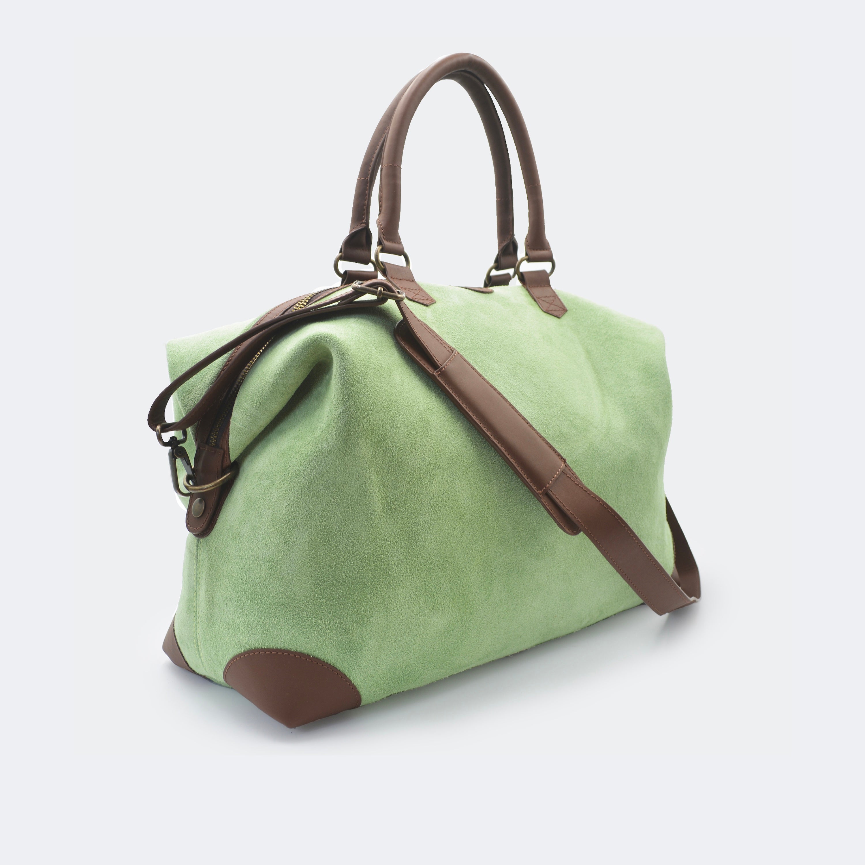 The Valise in mint green leather, shown with its removable full-grain leather shoulder strap attached — designed for hands-free carry and versatile travel.