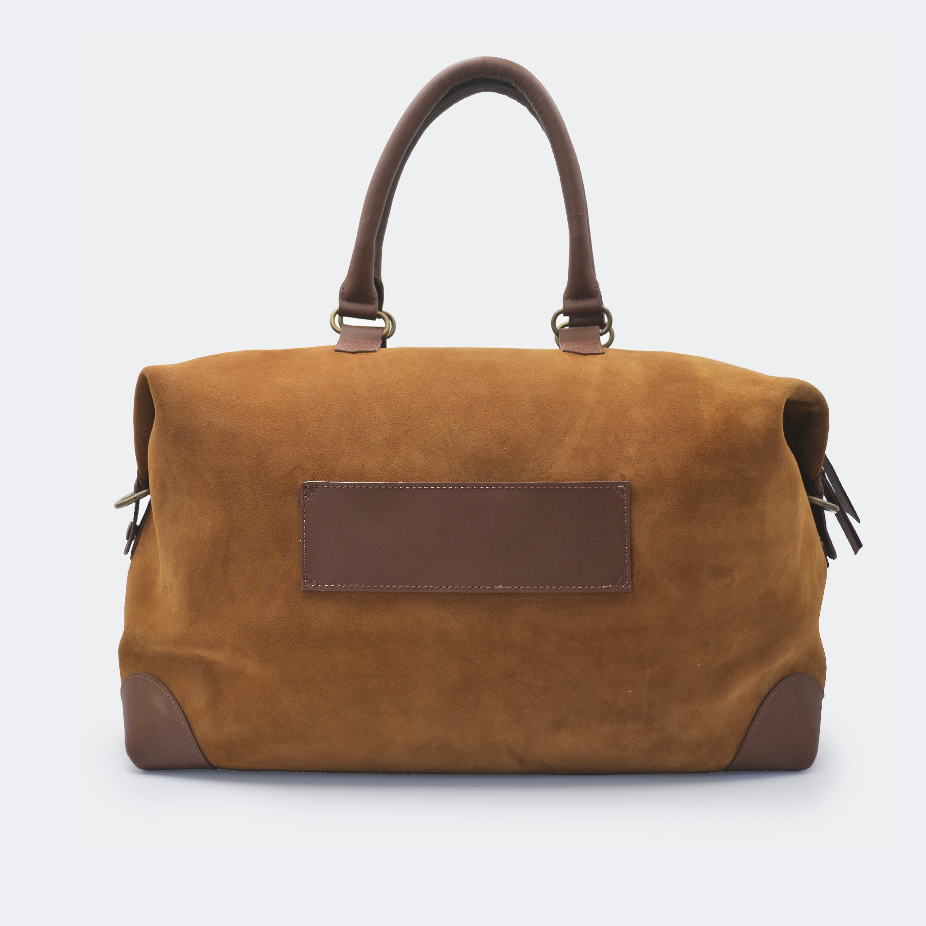 The Valise in brown leather shown from behind, highlighting the integrated luggage band designed to slide over a suitcase handle.