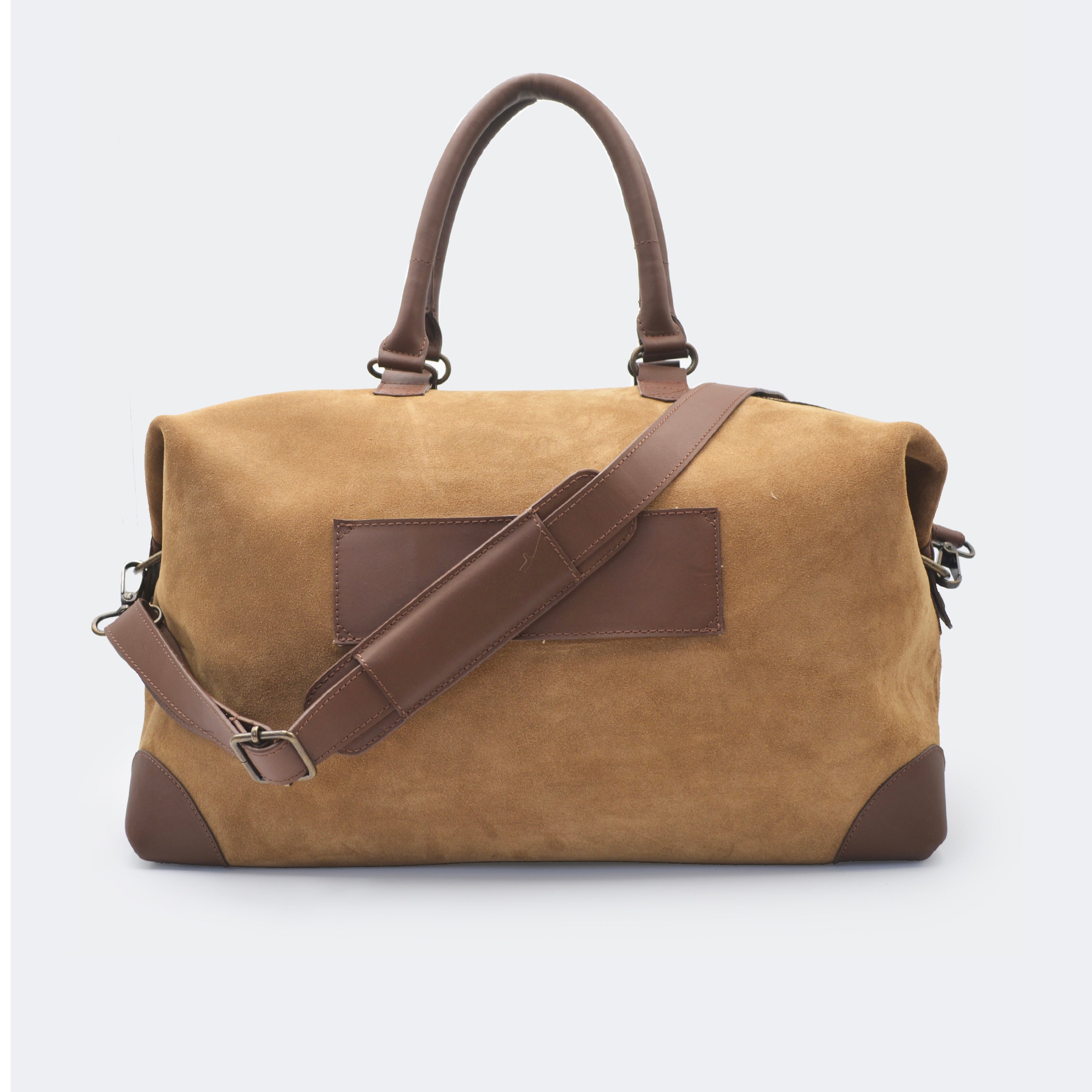 The Valise in brown leather shown from behind, highlighting the integrated luggage band designed to slide over a suitcase handle.