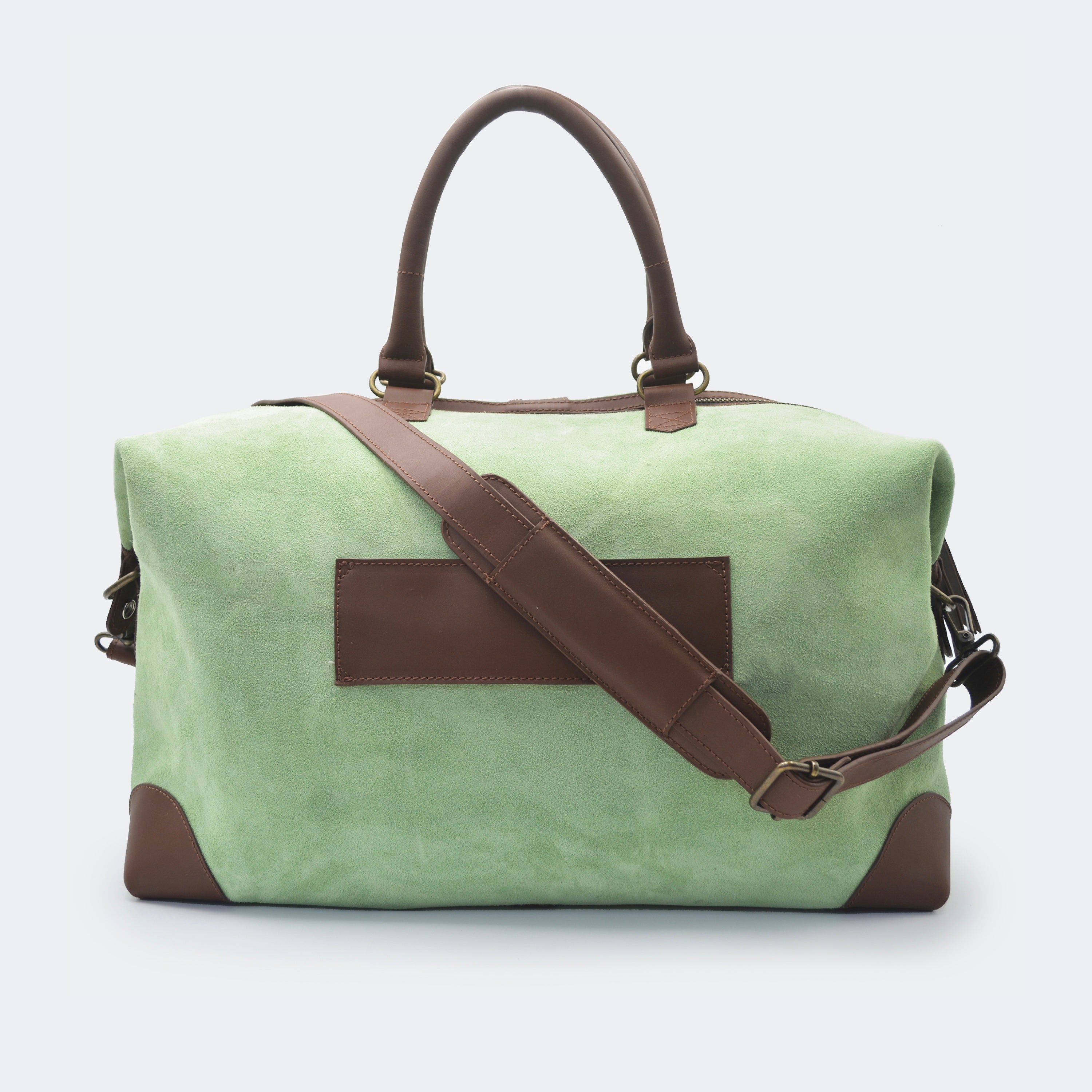 The Valise in mint green leather shown from behind, highlighting the integrated luggage band designed to slide over a suitcase handle.