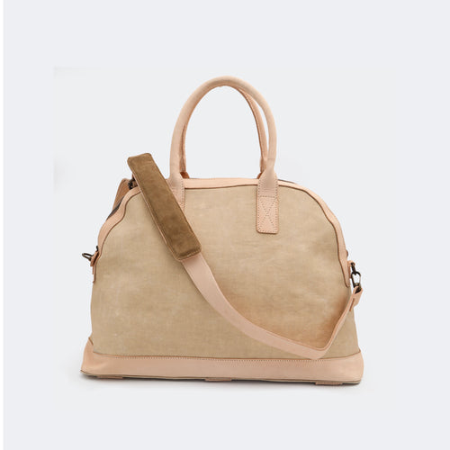 The Weekender in tan, shown with its removable leather shoulder strap attached — designed for comfortable, hands-free travel.