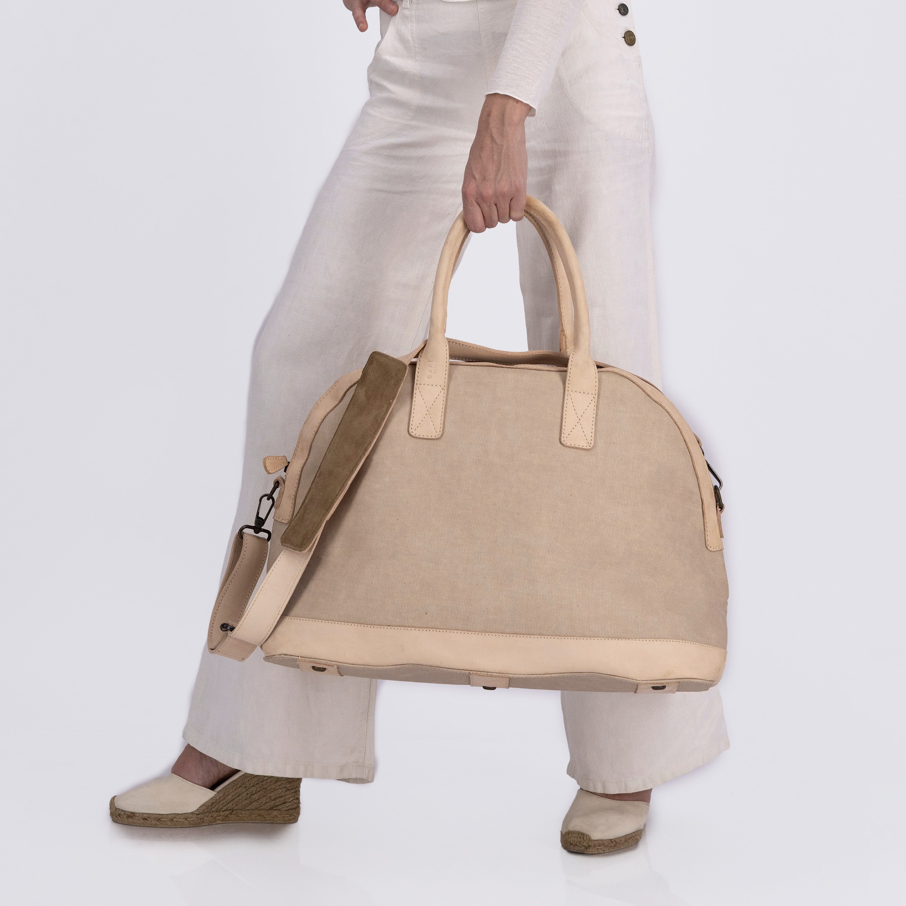 The Weekender in tan, carried by a model to show scale and styling — a classic weekender bag ideal for short trips.