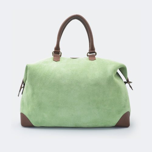 The Valise in mint green leather, crafted from full-grain leather with structured sides and curved handles — a minimalist travel bag blending elegance and utility.